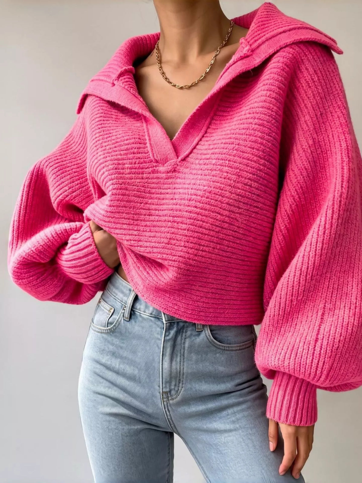 Woman wearing a hot pink oversized collar ribbed cropped sweater