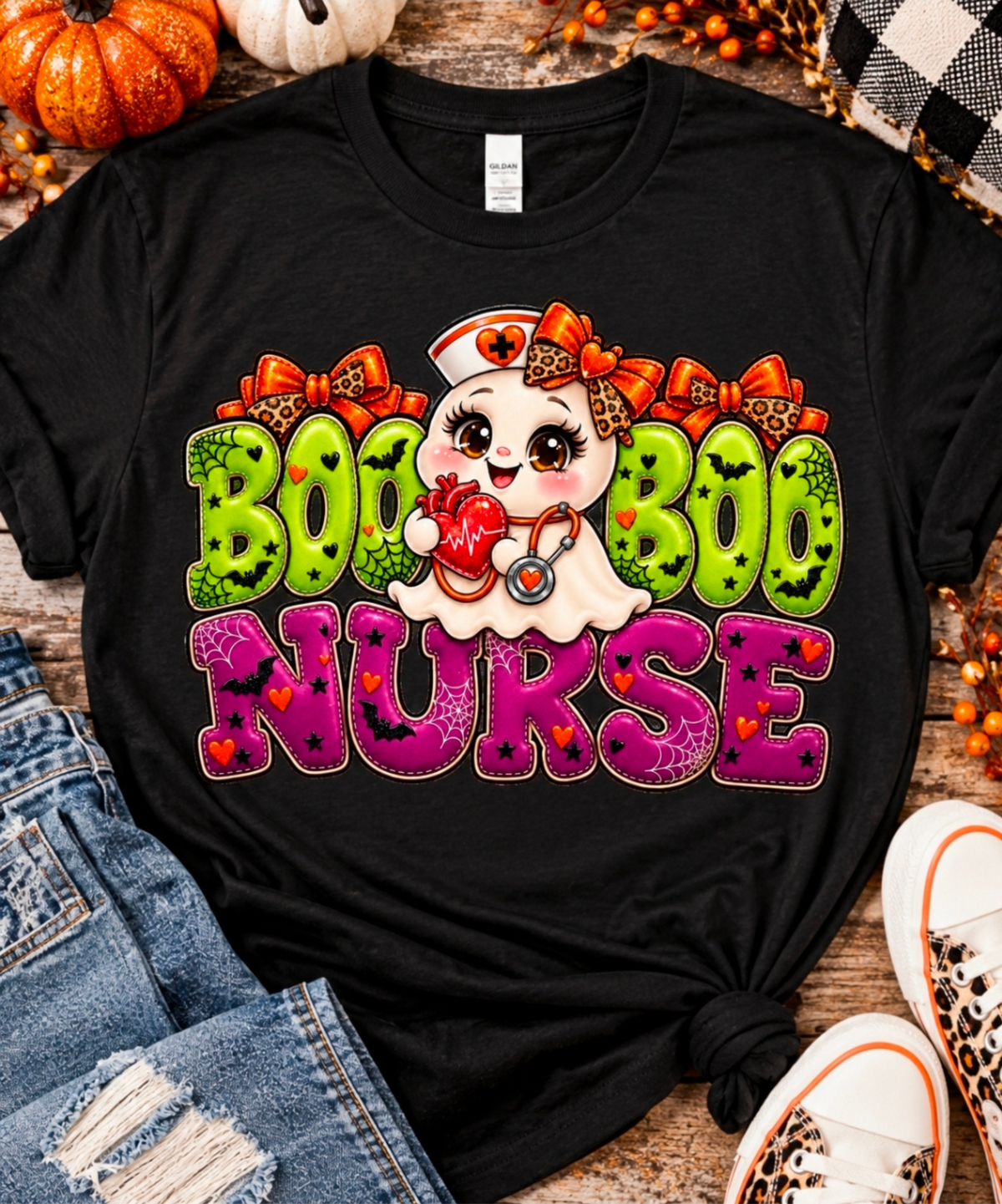 Black Boo Boo Nurse Halloween graphic T-shirt displayed on rustic wood with pumpkins, distressed jeans and leopard sneakers.