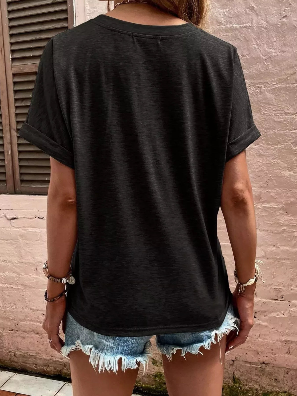 Women's black blouse showing rolled sleeve and back detail