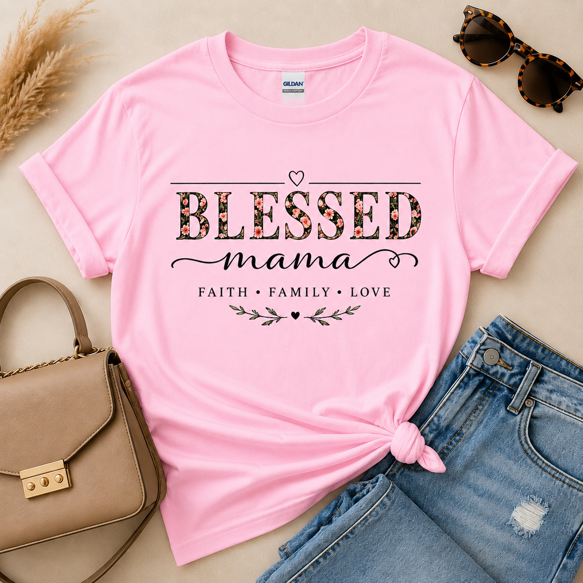 Blessed Mama Faith Family Love floral graphic shirt in Gildan light pink, styled with blue jeans and neutral accessories.