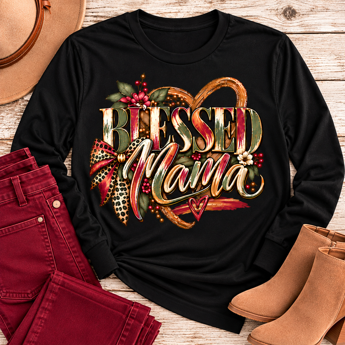 Black long-sleeve Blessed Mama shirt arranged with cranberry-colored pants and tan boots in a rustic boutique flat-lay.