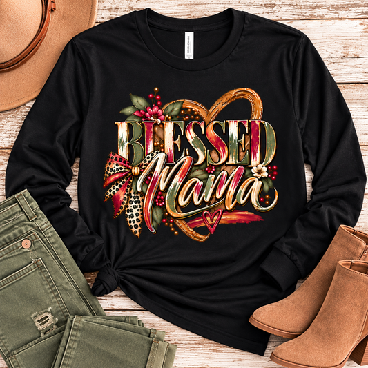 Black long-sleeve Blessed Mama graphic shirt styled flat with olive-green pants and tan ankle boots on a rustic wood background.