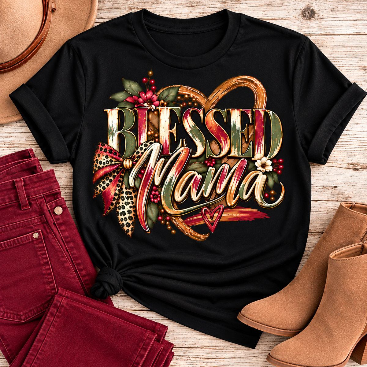 Black short-sleeve Blessed Mama graphic tee styled with cranberry-colored pants and tan ankle boots in a Southern boutique flat-lay.