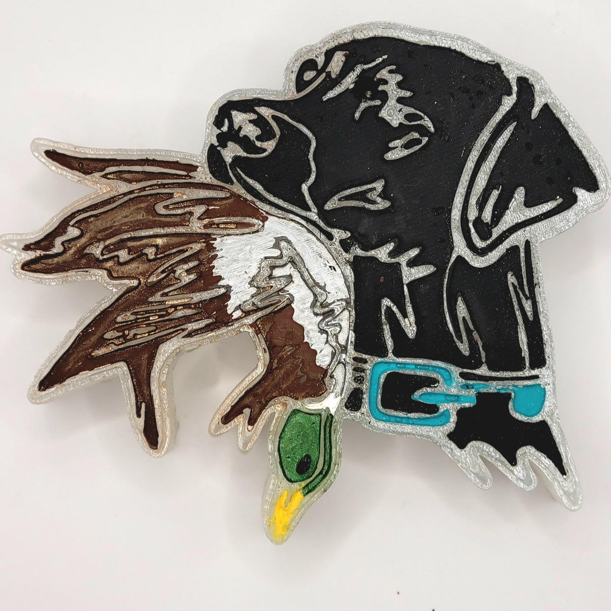 Black Labrador and duck freshie with brown and white feather details and turquoise collar on a light background.