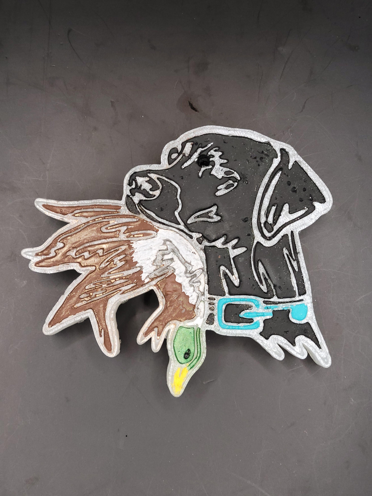 Full view of the black Lab and duck freshie on a gray background.