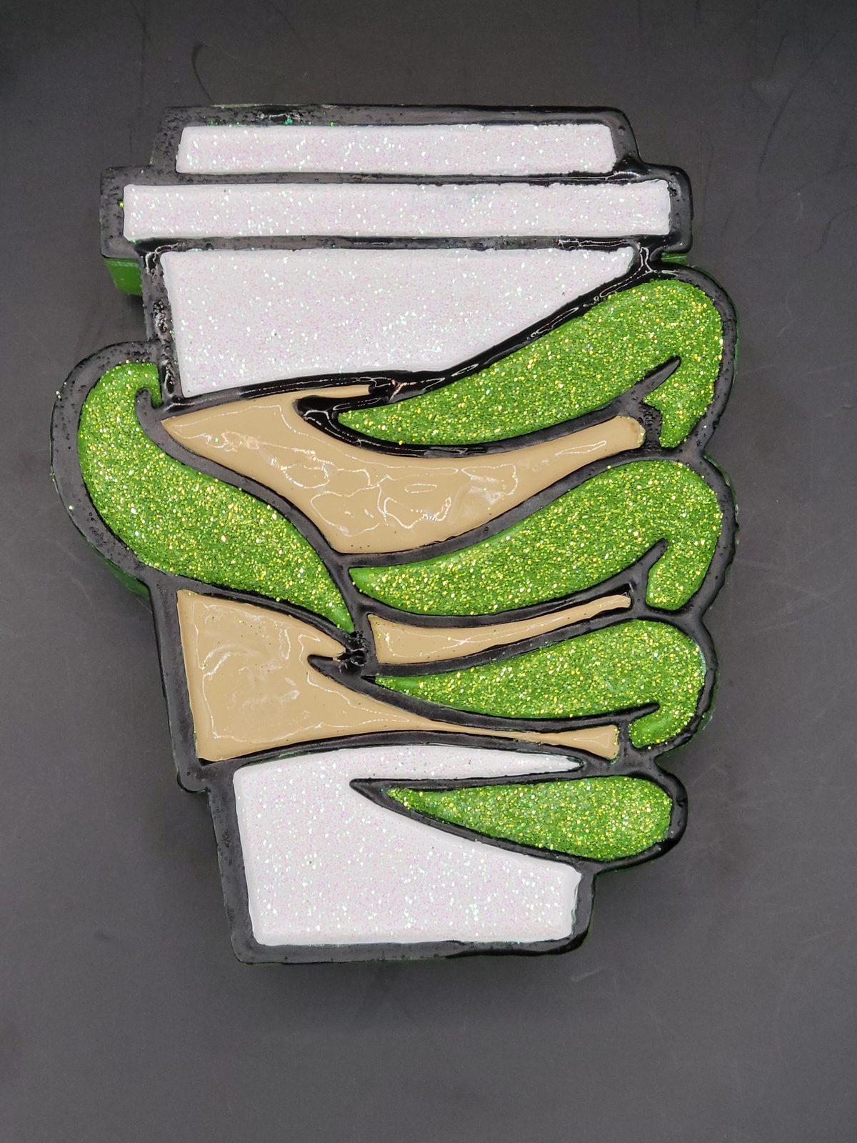 Green hand coffee cup freshie displayed on a dark gray background.