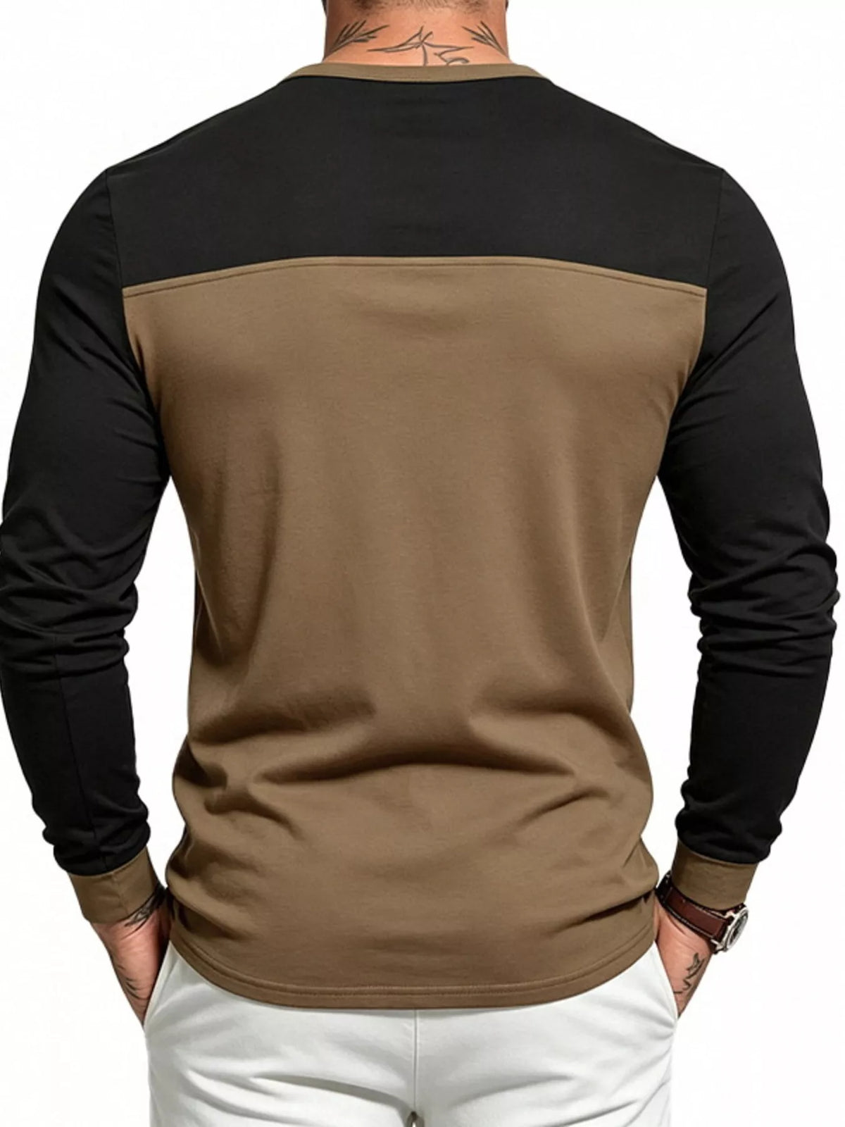Man wearing a dark brown and black color block long sleeve Henley shirt, back view
