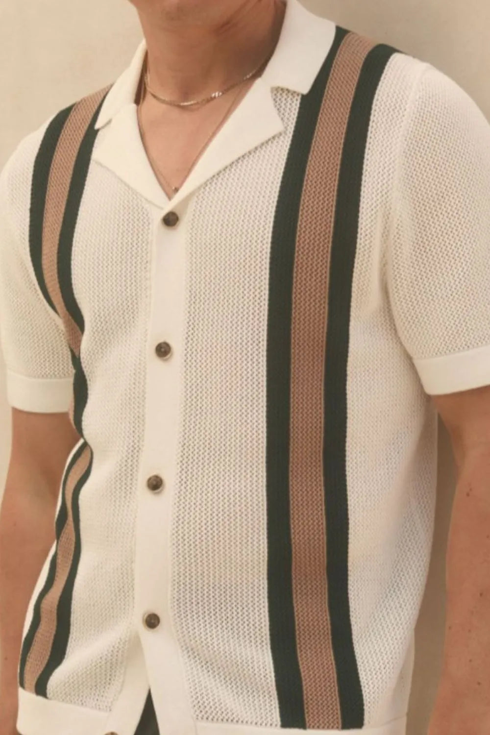 Close-up of men's ivory short sleeve button-down shirt with textured knit and contrast vertical stripes