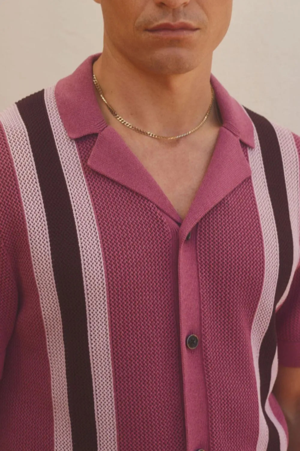 Close-up of men's red-violet short sleeve button-down shirt with textured knit and contrast vertical stripes