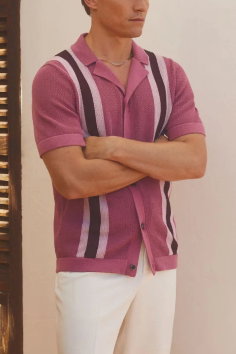Man wearing a red-violet short sleeve button-down shirt with contrast vertical stripes