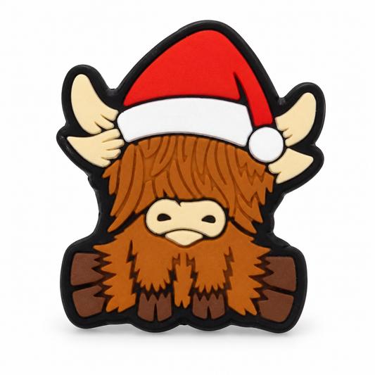 Christmas Highland cow focal bead with a red Santa hat, cream horns, shaggy brown hair and black outlined edges on white.