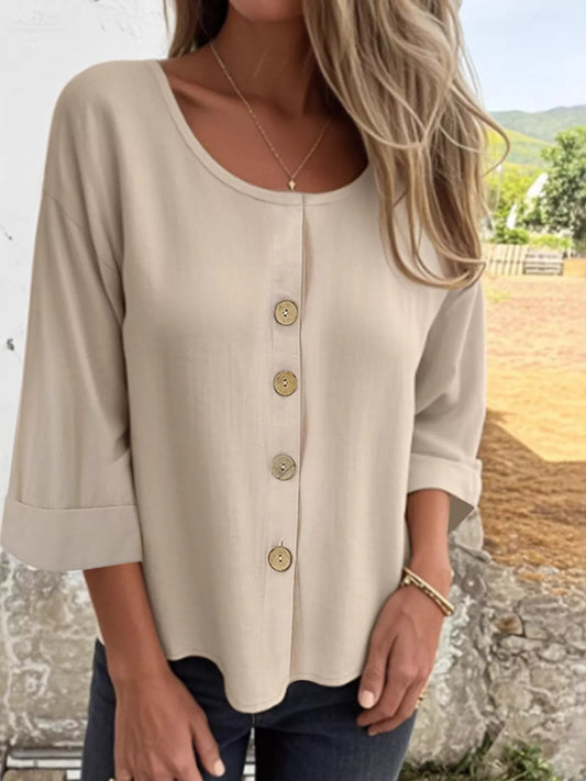 Woman wearing a beige V-neck button-front 3/4 sleeve blouse