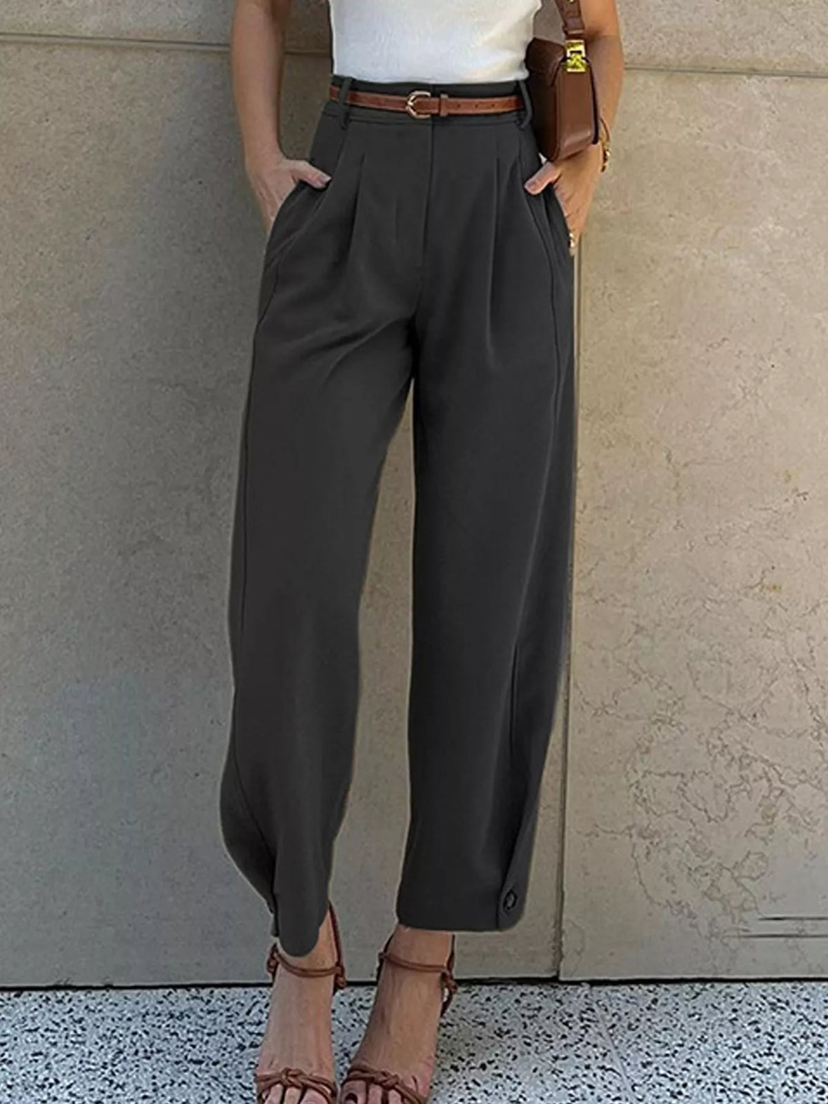 Woman wearing black high-waisted pleated straight-leg pants