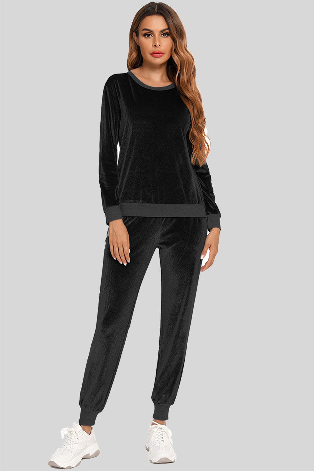 Woman wearing a black round neck long sleeve loungewear set with matching pocketed pants, full-length view