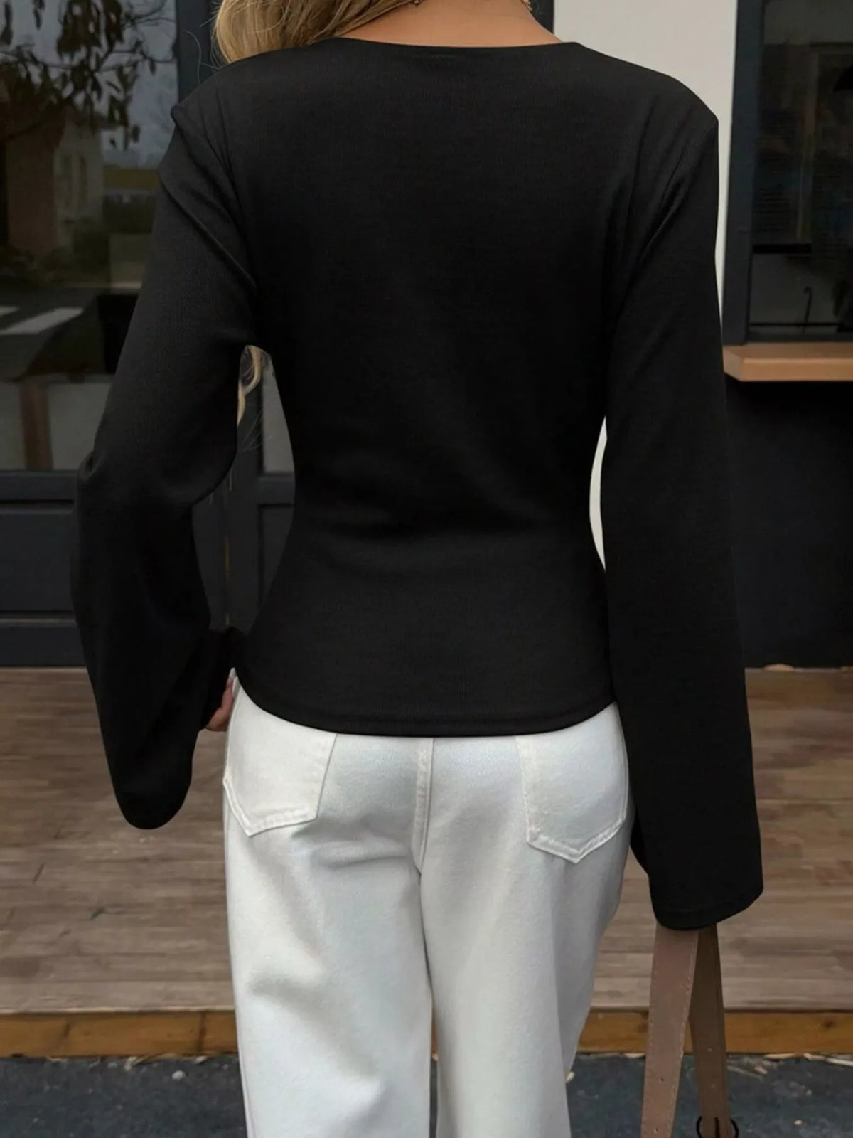 Back view of women's black asymmetrical long sleeve blouse