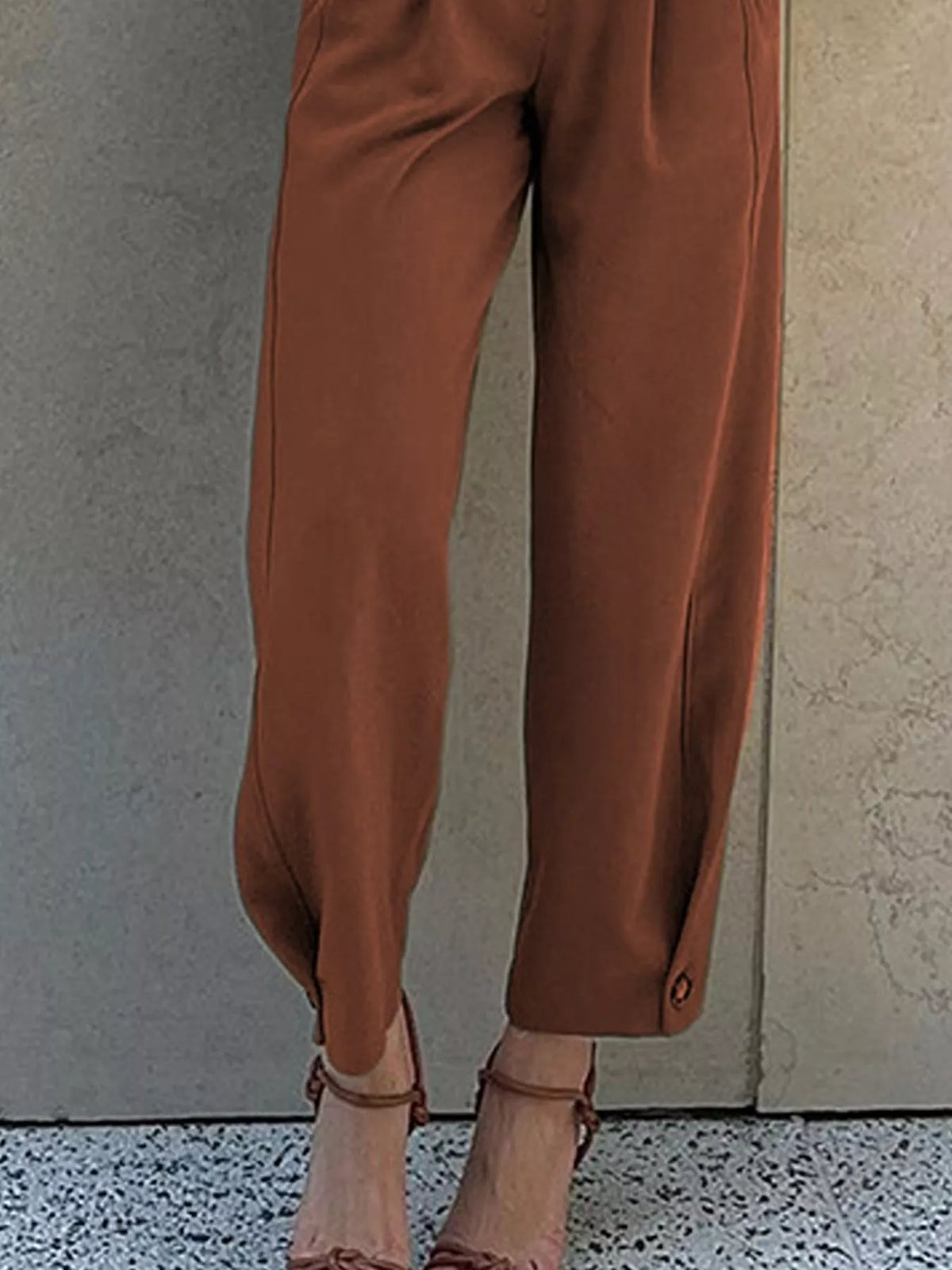 Side view of women's brown high-waisted pleated pants