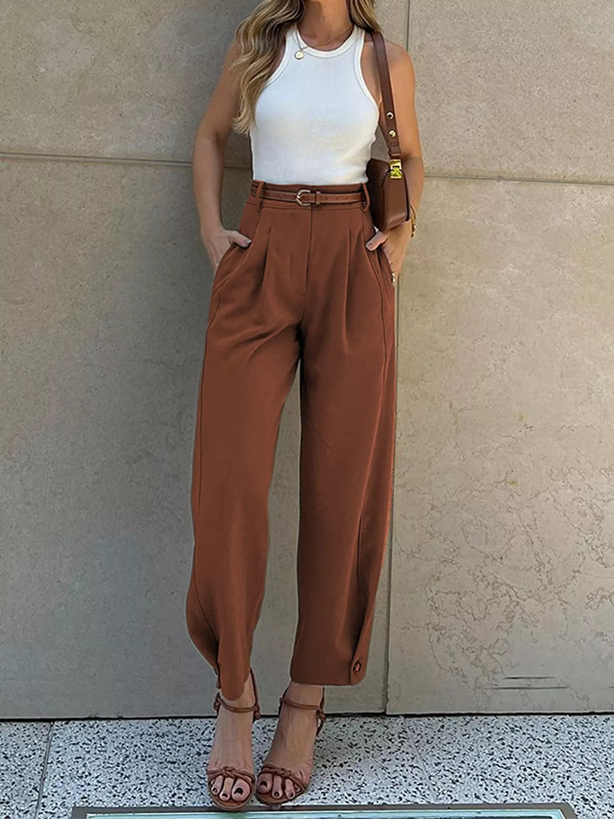 Woman wearing brown high-waisted pleated straight-leg pants