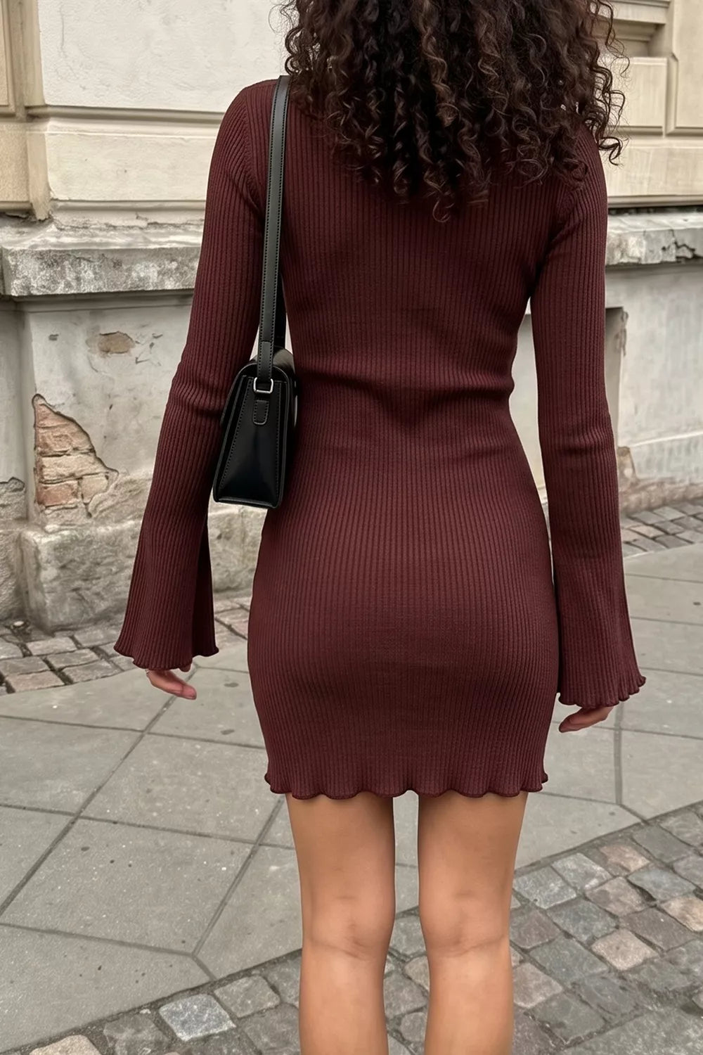 Woman wearing a burgundy mock neck ribbed bodycon mini dress, back view