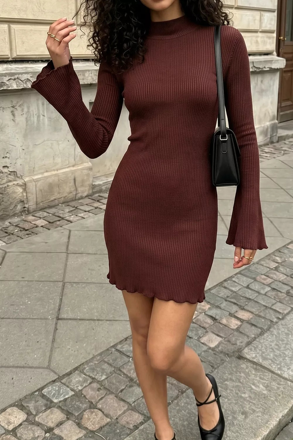 Woman wearing a burgundy mock neck ribbed bodycon mini dress with long bell sleeves, full-length view