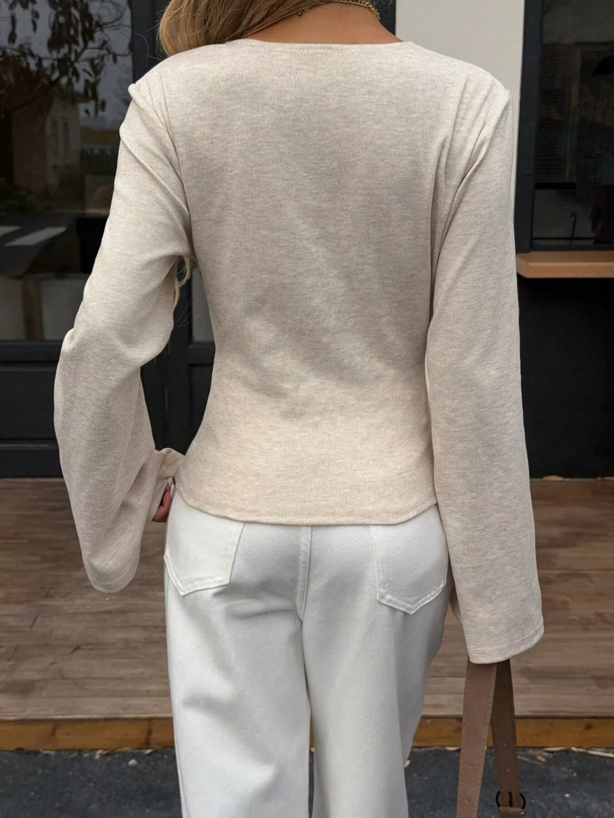 Back view of women's milky white asymmetrical long sleeve blouse