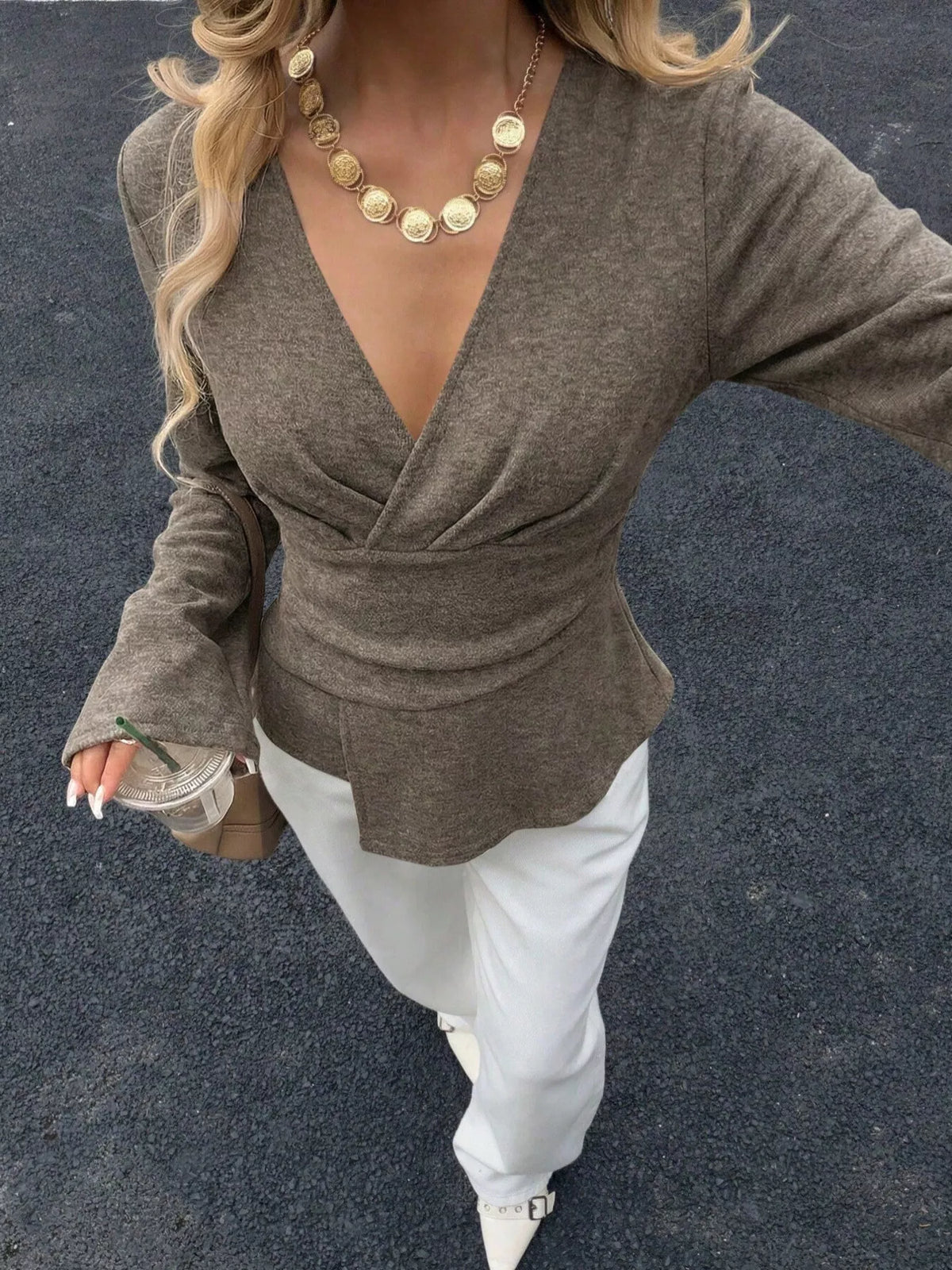 Woman wearing an olive V-neck wrap asymmetrical blouse with flared sleeves