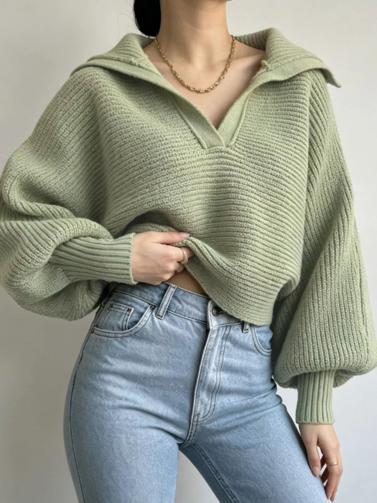 Woman wearing a sage green oversized collar ribbed cropped sweater