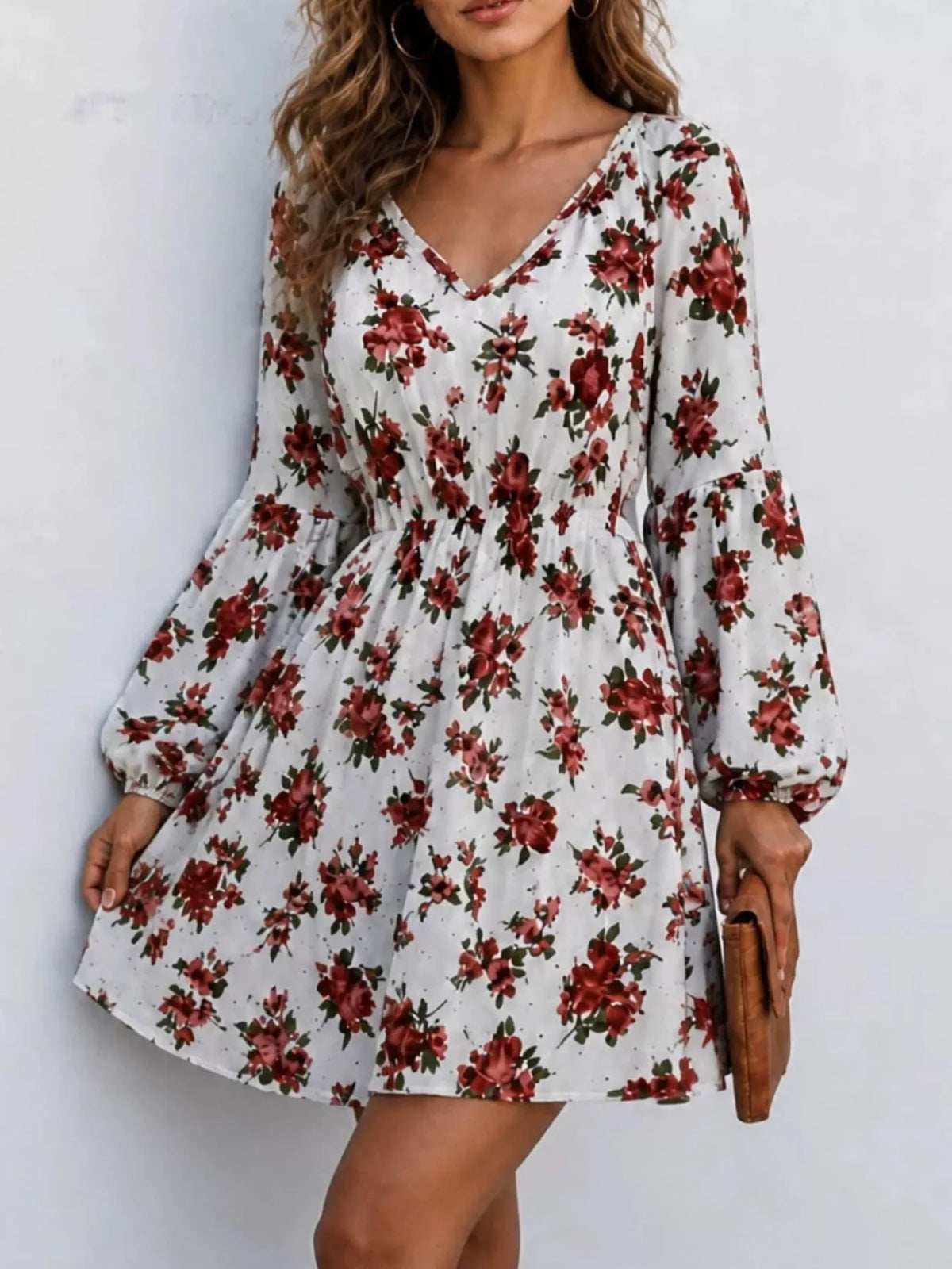 Woman wearing a white floral print V-neck long sleeve mini dress, front view