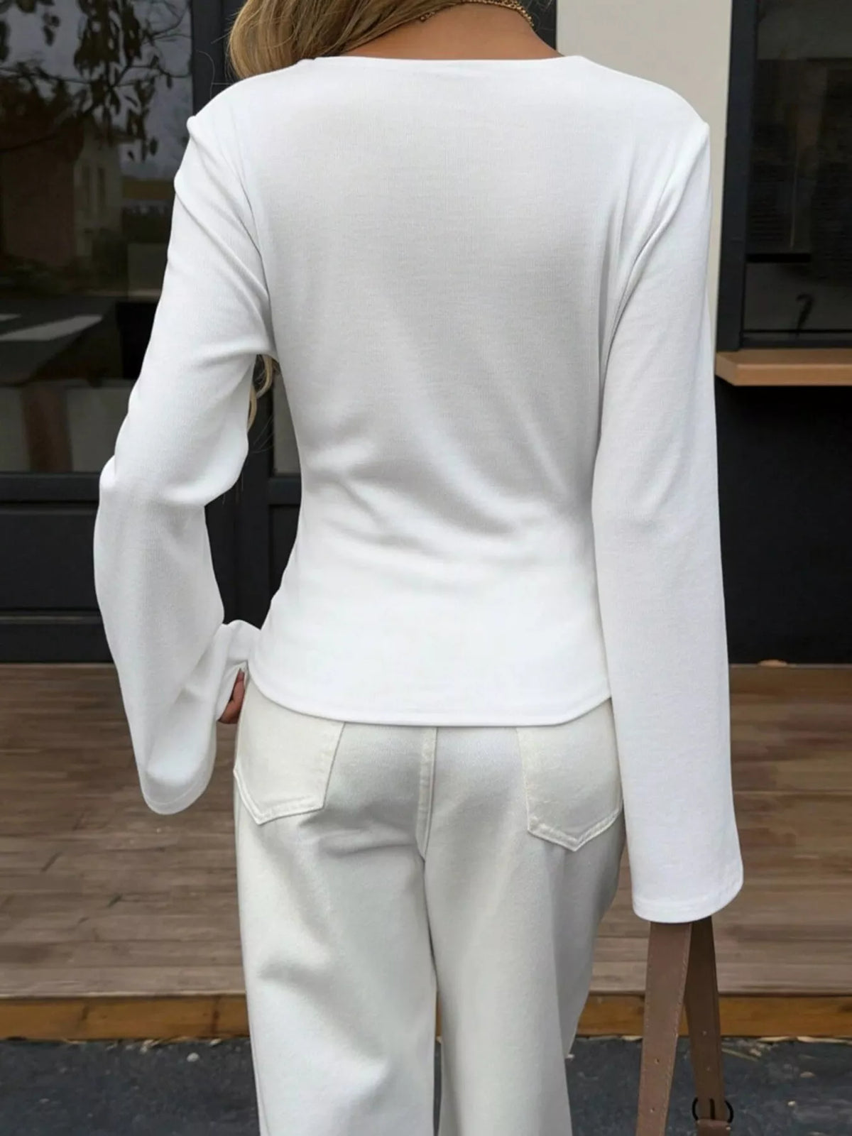 Back view of women's white asymmetrical long sleeve blouse